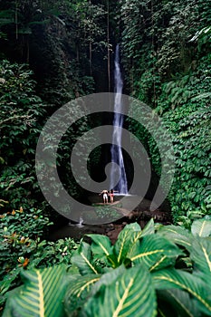 Young couple tourism enjoying the Leke Leke waterfall at Bali