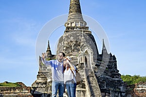 young couple tourist taking selfie while visiting at Wat Phra Si Sanphet photo