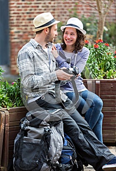 Young couple of tourist watching photographs during a break