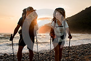 young couple tourists look at each other against the background of sunset