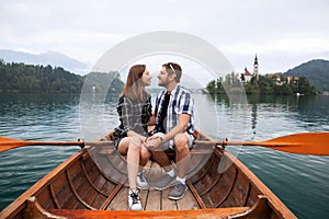 Young couple of tourists on wooden boat on the Lake Bled, Slovenia