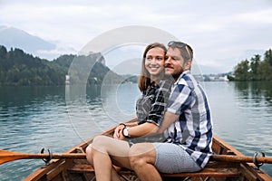 Young couple of tourists on wooden boat on the Lake Bled, Slovenia