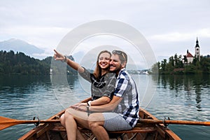 Young couple of tourists on wooden boat on the Lake Bled, Slovenia