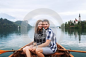 Young couple of tourists on wooden boat on the Lake Bled, Slovenia