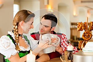 Young couple in traditional Bavarian Tracht in restaurant or pub