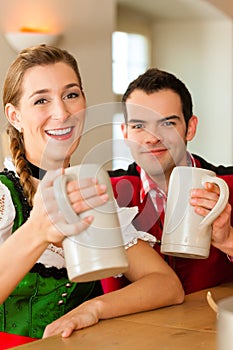 Young couple in traditional Bavarian Tracht in restaurant or pub