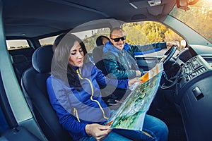 Young couple traveling by car through the picturesque autumn forest.