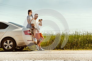 Young couple traveling on the car in sunny day