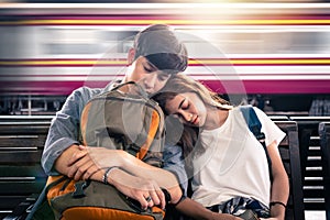 Young couple traveller sleeping at the train station
