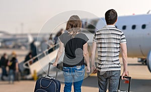 Young couple is travelling on vacation. Man and woman with baggage in airport