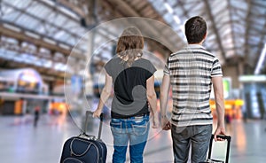 Young couple is travelling on vacation. Man and woman with baggage in train station