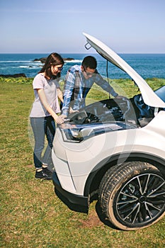 Young couple tries to fix the broken down car