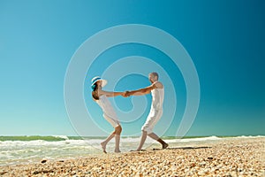 Young couple twirling on the beach