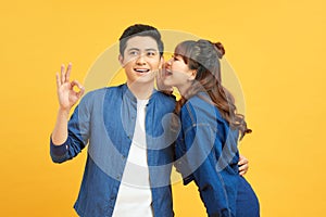 Young couple two friends guy girls posing isolated on yellow orange wall background. People lifestyle concept. Mock up copy space