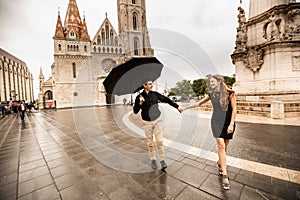 Young couple with umbrella walking in Budapest on a rainy day. Love story