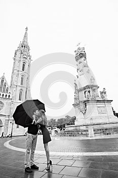 Young couple with umbrella walking in Budapest on a rainy day. Love story. Black and white