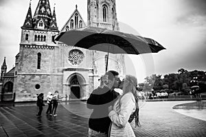 Young couple with umbrella walking in Budapest on a rainy day. Love story. Black and white