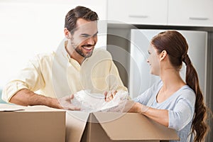 Young couple unpacking boxes in kitchen