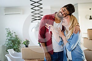 Young couple unpacking cardboard boxes at new home moving in concept