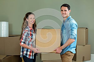 Young couple unpacking carton boxes in their new house