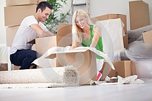 Young couple unpacking or packing boxes