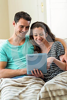 Young couple using a digital tablet on sofa