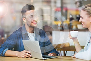 Young couple using laptop at cafe