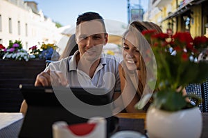 Young couple using a laptop in a cafe. portrait of a happy young couple using a digital tablet together in a cafe.