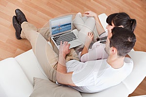 Young couple using laptop in couch