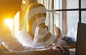 Young Couple Using Laptop On Desk At in a modern office, loft style and think