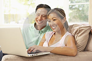 Young Couple Using Laptop At Home