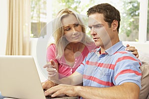 Young Couple Using Laptop At Home