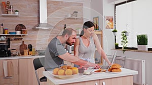 Young couple using laptop at the kitchen