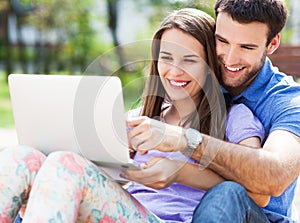 Young couple using laptop outdoors