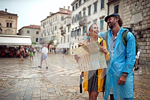 A young couple is using a map while walking the old city during a holiday on the seaside. Vacation, tourists, relationship,