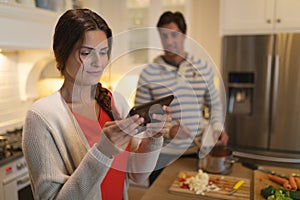 Young couple using tablet computer while cooking