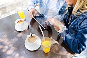 Young couple using tablet while sitting together at cafe