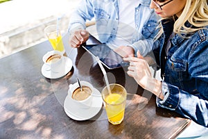 Young couple using tablet while sitting together at cafe