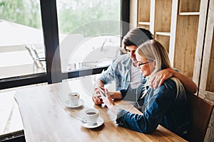 Young couple using tablet while sitting together at cafe