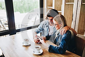 Young couple using tablet while sitting together at cafe