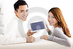 Young couple using tablet on sofa