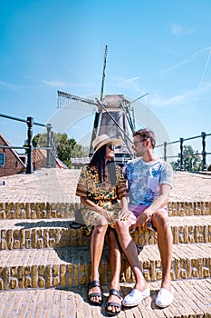 Young couple on vacation Friesland Netherlands Sloten, old town of Sloten Netherlands with canals and windmill