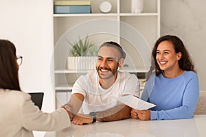 Young couple visiting doctor, shaking hand, happy with results