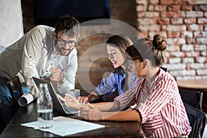 A young couple and a waitress enjoying laptop content