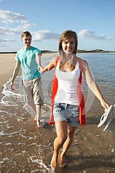 Young Couple Walking Along Shoreline