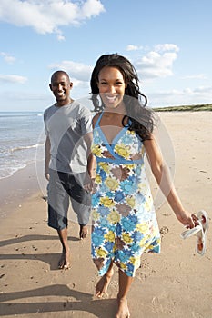 Young Couple Walking Along Shoreline