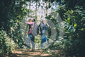 Young couple walking with backpacks in forest. Adventure hikes,