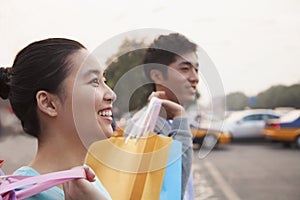 Young couple walking down the street with shopping bags in Beijing, close-up