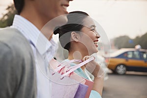 Young couple walking down the street with shopping bags in Beijing, close-up