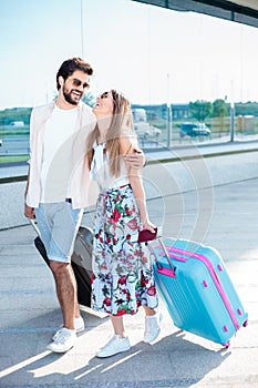 Young couple walking in front of an airport terminal building